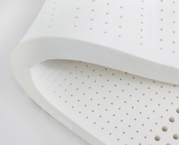 hand presses inside an opened foam mattress